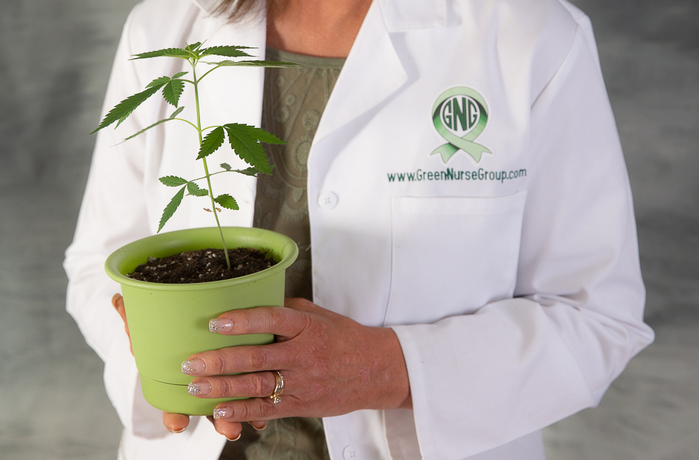 Jodi holding canibis plant in her nurses uniform branding shot